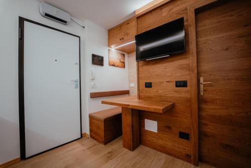 Cette chambre dispose d'une porte, d'un bureau et d'une télévision. dans l'établissement Monolocale La casa delle fate, à Madonna di Campiglio