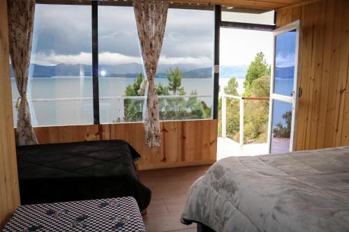 a bedroom with a large window with a view of the water at Villa del lago Glamping in Tota