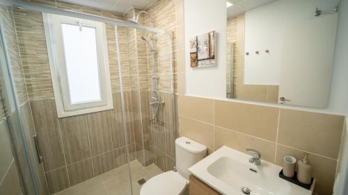 a bathroom with a toilet and a sink and a shower at Olivar Gines 10 MINUTOS A SEVILLA in Ginés