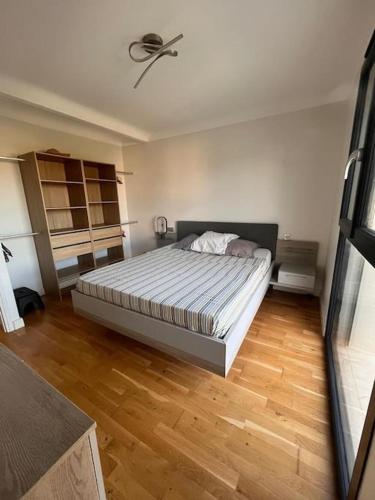 une chambre avec un lit et un parquet dans l'établissement Grand appartement 4 personnes à 150m de la plage, au Barcarès