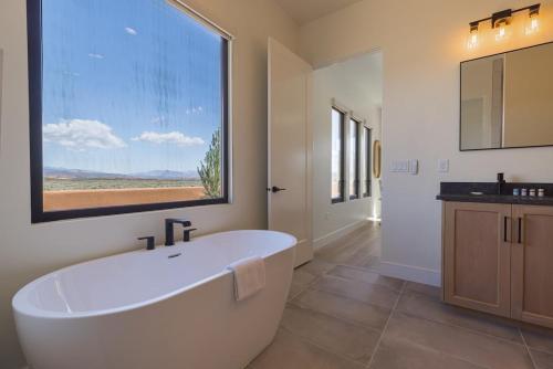 ein Badezimmer mit einer weißen Badewanne und einem großen Fenster in der Unterkunft About Time at Sand Hollow Resort in Hurricane