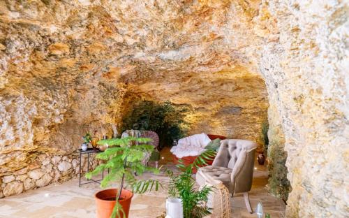 a living room with chairs and a stone wall at The Cave Apartment Xaghra in Xagħra