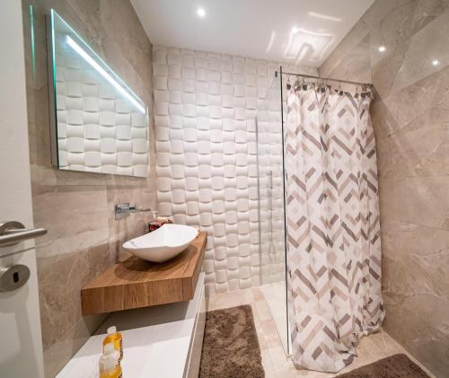 a bathroom with a sink and a shower at The Cave Apartment Xaghra in Xagħra