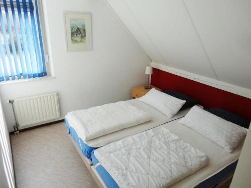 ein kleines Schlafzimmer mit zwei Betten und einem Fenster in der Unterkunft Bungalow in Breskens near the Lighthouse in Breskens