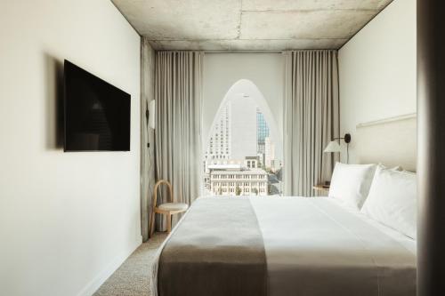 a hotel room with a large bed and a window at Populus in Denver