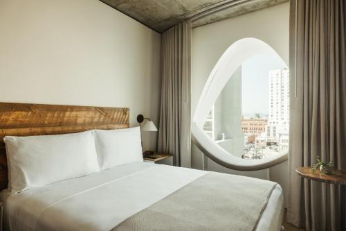 a bedroom with a large bed and a large window at Populus in Denver