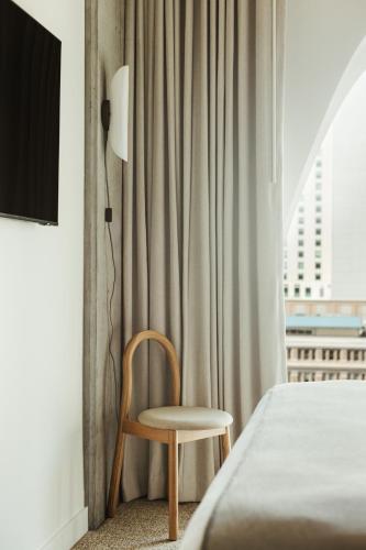 a chair sitting next to a bed in a room at Populus in Denver