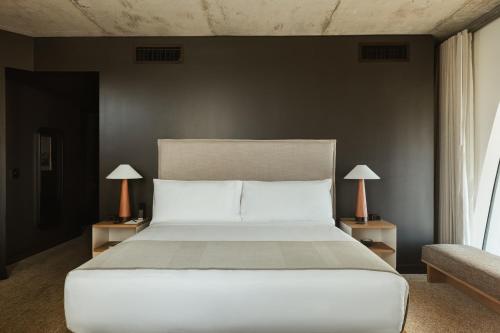 a bedroom with a white bed and two lamps at Populus in Denver