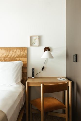 a bedroom with a bed and a desk with a lamp at Populus in Denver