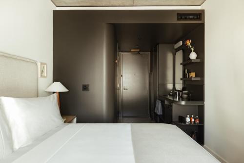 a bedroom with a large white bed and a doorway at Populus in Denver