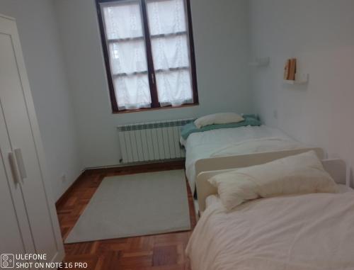 a room with three beds and a window at La Casita de Usaya in Ezcaray