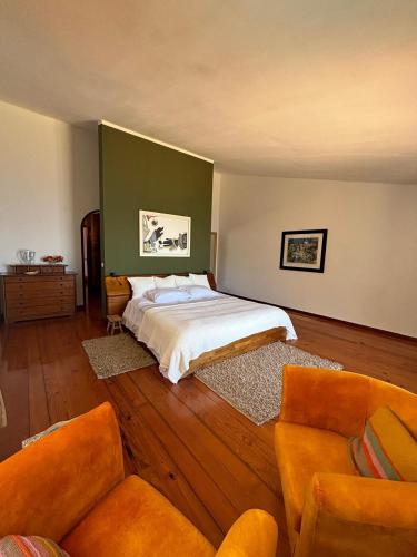 a bedroom with a bed and two couches at Suite Bela Vigia 2 in Jardim do Mar