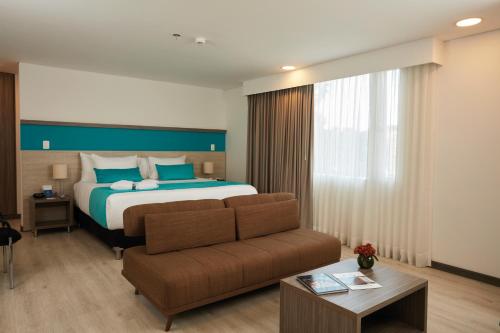 a hotel room with a bed and a couch at Hotel Nivari Duitama in Duitama