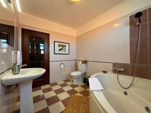 a bathroom with a sink and a tub and a toilet at Suite Bela Vigia 2 in Jardim do Mar