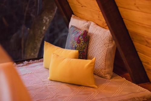 a group of pillows sitting on top of a bed at Entre Serras & Águas in Capitólio