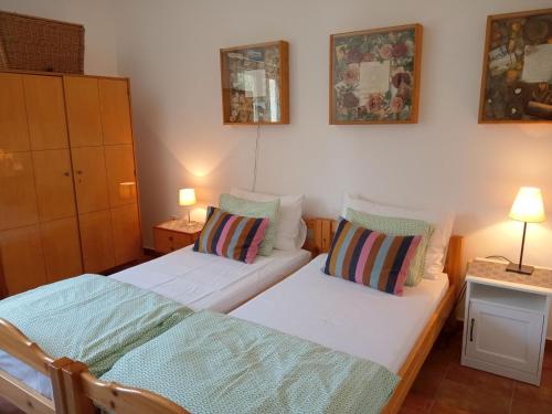 two beds in a small room with two lamps at House Paisley Dream in Ugljan