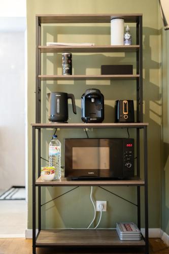 une étagère avec un four micro-ondes. dans l'établissement Green Dream Proximite Paris & Disneyland, à Villiers-sur-Marne