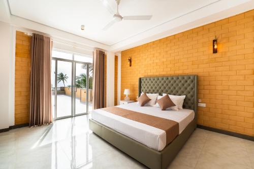 a bedroom with a bed and a brick wall at Bliss Blessings Villa & Spa - Hikkaduwa in Hikkaduwa