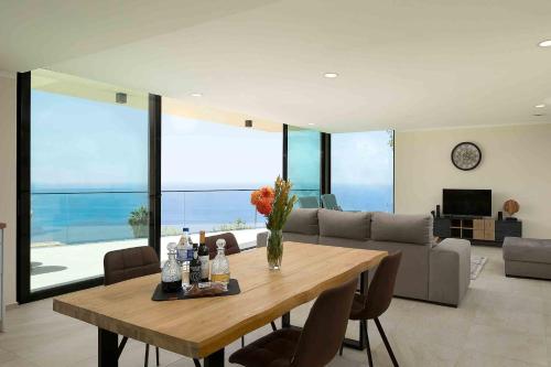 a living room with a table and a couch at Villa Ohana in Estreito da Calheta