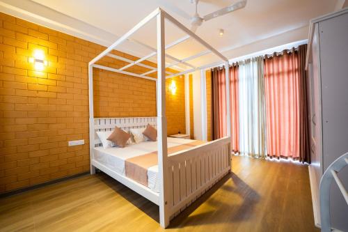 a bedroom with a white canopy bed in a room at Bliss Blessings Villa & Spa - Hikkaduwa in Hikkaduwa
