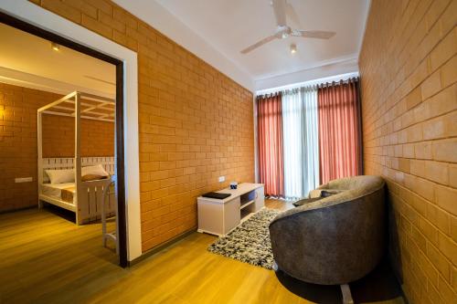 a living room with a chair and a bedroom at Bliss Blessings Villa & Spa - Hikkaduwa in Hikkaduwa