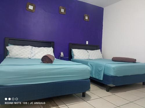 two beds sitting next to each other in a room at Casa sencilla, primer piso bien ubicada in Mazatlán