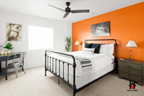 an orange bedroom with a bed and a desk at Sonoran Desert Getaway with Cowboy Tub in Cave Creek
