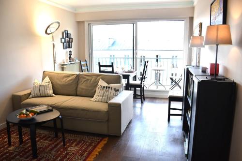 un salon avec un canapé et une table dans l'établissement Elégant et lumineux à 500 m Paris Expo Porte de Versailles, à Issy-les-Moulineaux