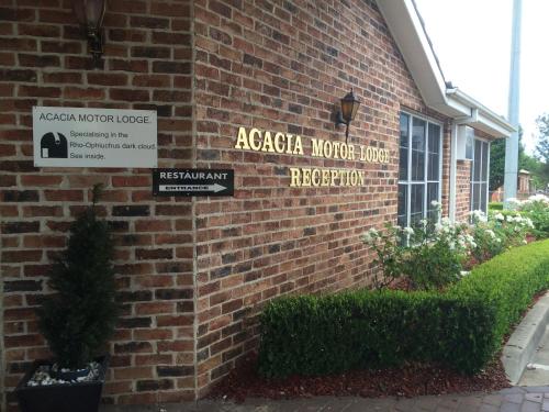 a brick building with a sign for a acacia mortar house at Acacia Motor Lodge in Coonabarabran