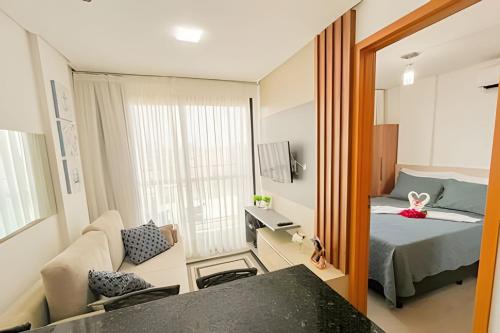 a small room with a bed and a mirror at Aconchego, varandinha e vista mar em Maracaípe in Porto De Galinhas