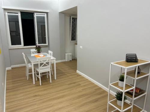 une salle à manger avec une table et des chaises blanches dans l'établissement Vomero Suite and Deluxe Room B&B Napoli, à Naples