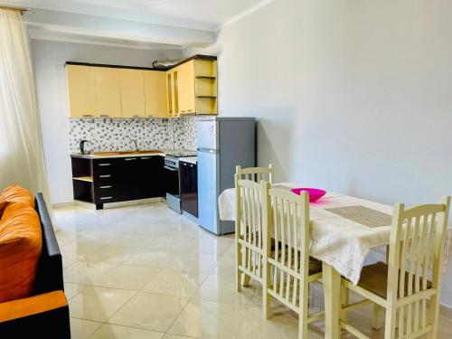 a kitchen with a table and chairs in a room at EasySleep City Center in Divjakë