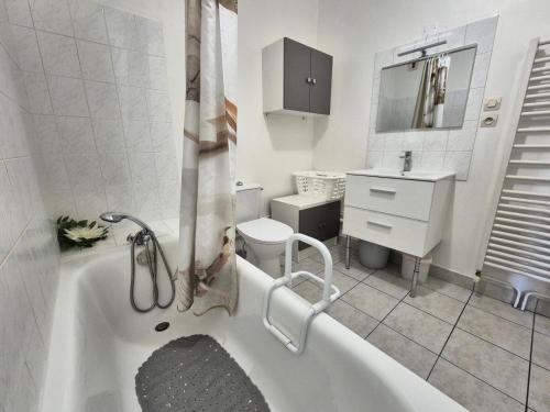 La salle de bains blanche est pourvue d'une baignoire et de toilettes. dans l'établissement Residence Du Temple - Agréable studio, très fonctionnel et bien agencé ! MAE-7124, à Aix-les-Bains