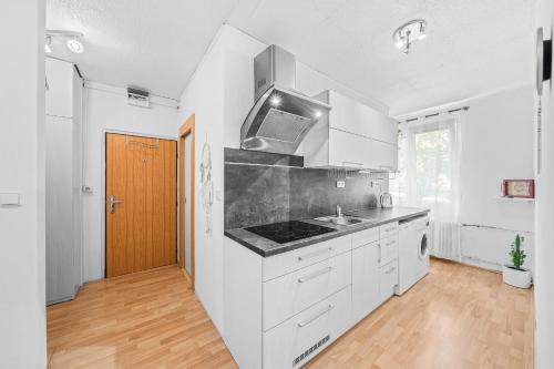 a kitchen with white cabinets and a stove top oven at Ubytování kousek od Plzně in Kaznějov