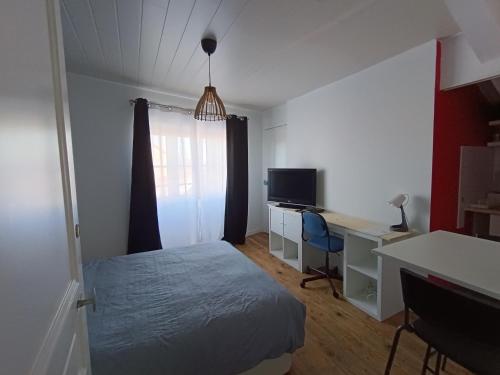 une chambre avec un lit et un bureau avec un ordinateur dans l'établissement Studette pour 1 ou 2 personnes, à Chaumont