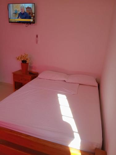 a bedroom with a bed with a tv on the wall at Apartamentos Datalu in Coveñas