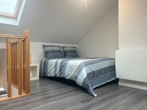 une chambre avec un lit avec des oreillers bleus dessus dans l'établissement Appartement cosy, à Lesquin