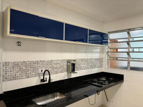 een badkamer met een wastafel en een raam bij Apto Vista Mar com Ar cond, Piscina, Wifi, TV e Garagem 2 vagas in São Vicente