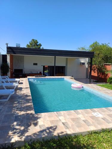 a swimming pool with a frisbee in front of a house at Vivíana Hause Hospedaje in Cambyretá