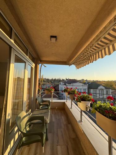 a balcony with chairs and flowers on a building at Bed & Coffee LUKAS Krusevac in Kruševac