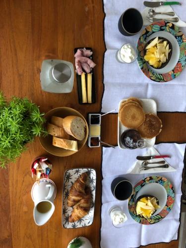 a table topped with plates of food on a table at Chambre Manava in Avae