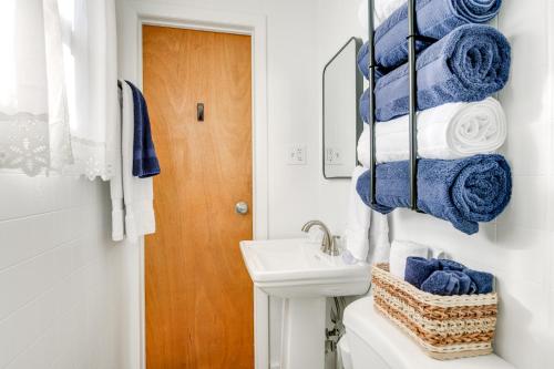 Un baño con inodoro, lavabo y toallas azules. en Walk to Lake Erie Shore Quiet Getaway with Fire Pit, en Irving
