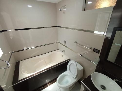 a bathroom with a tub and a toilet and a sink at Hidden Garden in Cusco