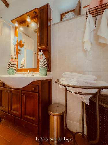 a bathroom with a sink and a mirror at Ferienwohnung Fortuna del Lupo mit Pool und Aussicht in Subbiano