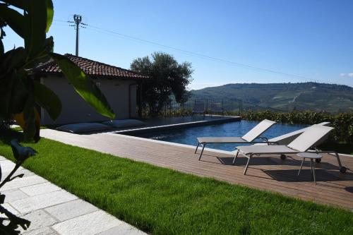 a swimming pool with two lounge chairs next to a house at Casa Schiavenza Perno in Monforte dʼAlba