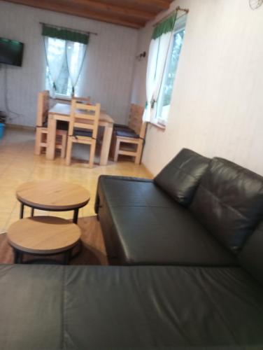 a living room with a couch and a table and chairs at Domek Rokitki in Rokity
