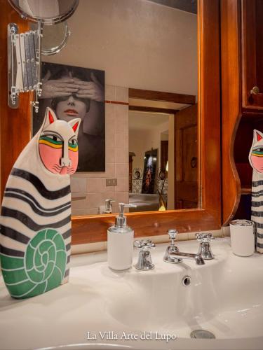 a bathroom sink with a towel of a cat on it at Ferienwohnung Fortuna del Lupo mit Pool und Aussicht in Subbiano
