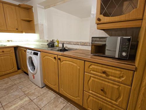 a kitchen with a microwave and a washing machine at Spacious, cozy double room 3 with amenities in Nottingham