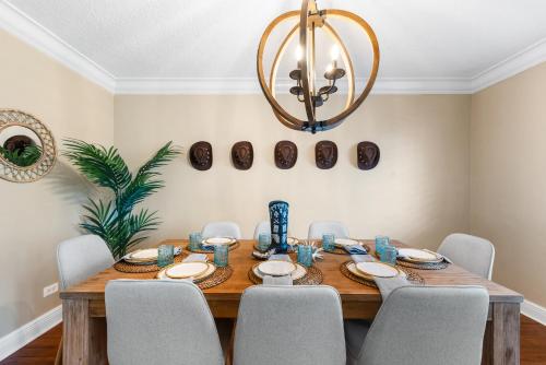 a dining room table with chairs and a chandelier at Centrally Located 4BD Oasis with Pool & Movie Patio in Hollywood