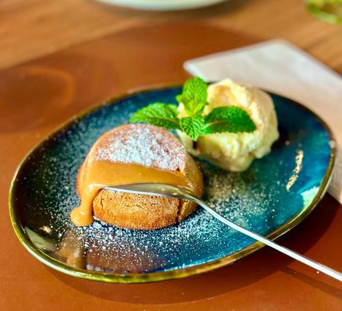 a blue plate with a pastry with a spoon at Hotel Casa Paradiso Guarujá in Guarujá